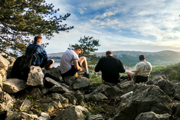 Men sitting down for a rest on a scenic mountainview stop during a hike